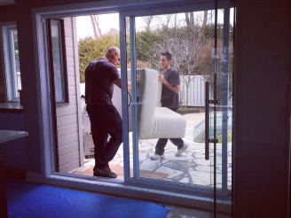 déménageurs de Déménagement AR Masson sortant un sofa par la porte patio d’une maison